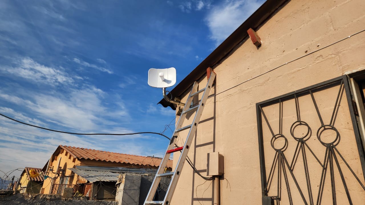 SkuifNet customer antenna installed on a home with ladder in place